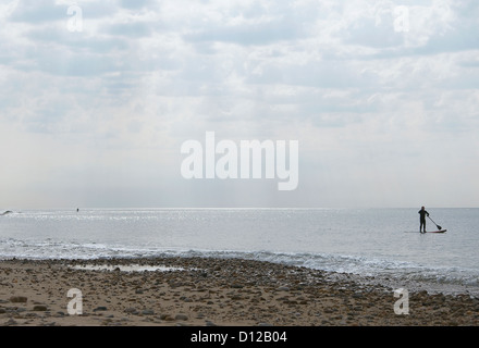 Un couple de stand up paddleboarders au large de la plage de Montauk pendant les heures tôt le matin à la plage des plaines de fossé. Banque D'Images