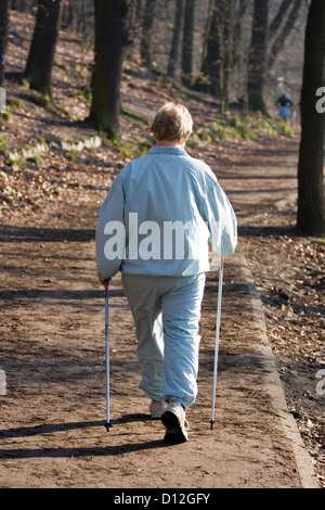 Berlin, Allemagne, femme plus âgée avec marche nordique dans une forêt Banque D'Images