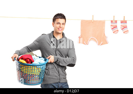 Smiling guy tenant un panier de blanchisserie et un fil à linge avec des vêtements isolé sur fond blanc Banque D'Images