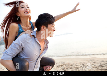 Heureux les jeunes jouant sur le dos la plage de Repulse Bay, Hong Kong Banque D'Images