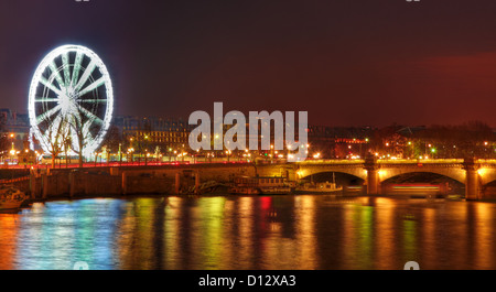 Image de l'allumé roue Ferry situé sur la Place de la Concorde et de reflets de lumière colorée dans la Seine à Paris. Banque D'Images