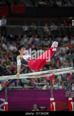 Kazuhito Tanaka (JPN) qui font concurrence aux barres parallèles durant la finale de l'équipe masculine des Jeux Olympiques de 2012, Londres Banque D'Images