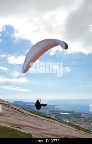 Concurrents au point de sauter au-dessus de la côte à l'Open International de parapente la concurrence dans Adeje, Tenerife, Canaries. 6e à 9e décembre 2012. 110 concurrents de 14 nationalités différentes participent à l'événement. Banque D'Images