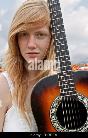 Une belle jeune fille est capturé tenant sa guitare acoustique. Banque D'Images