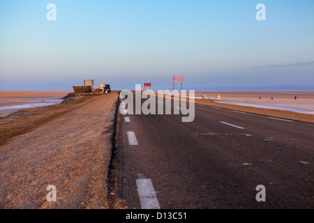 Large gamme d'asphalte à la frontière avec l'Algérie, de la Tunisie à l'aube à travers le lac salé chott El Jerid, Tunisie, Afrique Banque D'Images