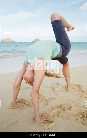 Hawaii, Oahu, Lanikai, jeune femme ne yoga sur la plage. Banque D'Images