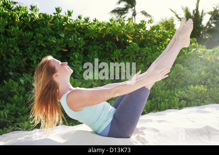 Hawaii, Oahu, Lanikai, jeune femme ne yoga sur la plage. Banque D'Images