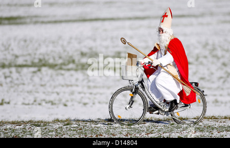 Un homme habille en St Nicholas tente de jouer dans une fanfare parade à l'aéroport de Friedrichshafen à Friedrichshafen, Allemagne, 06 décembre 2012. Nicholas déjà arrivée de Londres sur un avion du passager au service de l'avenir. Friedrichshafen-London Photo : Felix Kaestle Banque D'Images