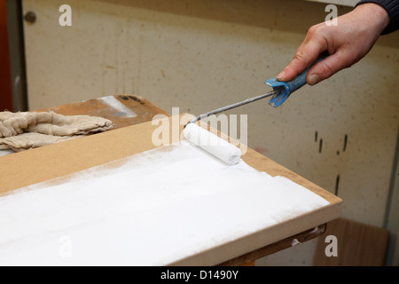 Peinture blanche sur un onglet avec un rouleau Banque D'Images