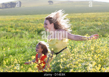 Sœurs jouant dans le champ de fleurs Banque D'Images