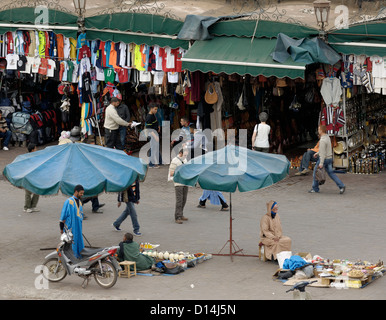 Des foules, des stands de nourriture et de magasins dans la place Djemaa El Fna, Marrakech, Maroc. Banque D'Images