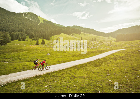 Couple riding bicycles on rural road Banque D'Images