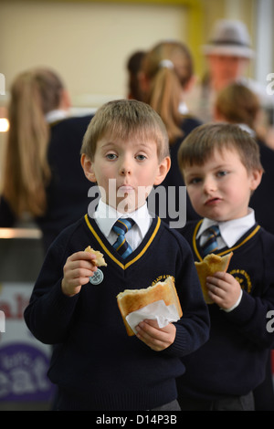 Un écolier eating toast après matin Assemblée générale à Notre Dame et St Werburgh's Catholic Primary School à Newcastle-under-Lyme, St Banque D'Images