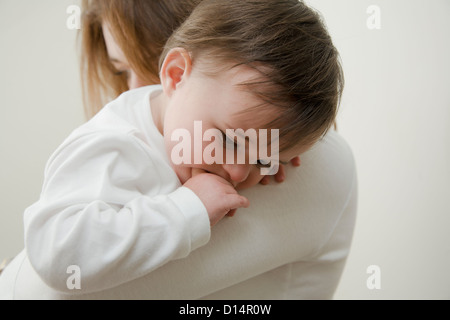 Mother holding daughter indoors Banque D'Images