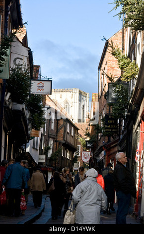 Consommateurs et aux touristes dans la pagaille un étroit de la rue médiévale à colombages York North Yorkshire angleterre Europe Banque D'Images