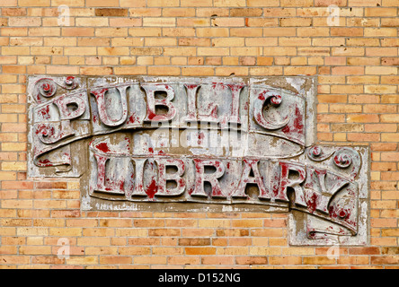 Signe de la bibliothèque publique sur mur de brique jaune Banque D'Images