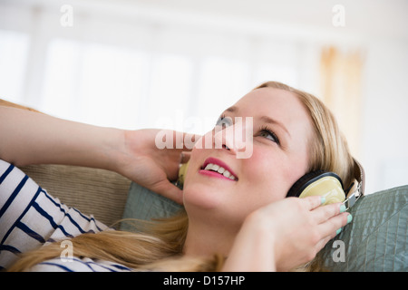 USA, New Jersey, Jersey City, Portrait of young woman listening music on headphones Banque D'Images