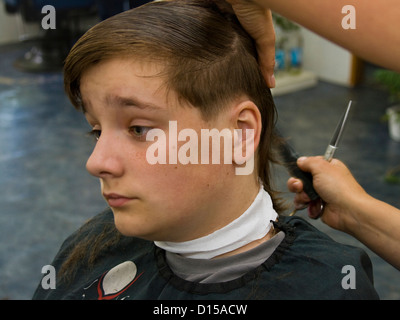 Adolescent garçon ayant une coupe de cheveux à la Hairdressers Banque D'Images