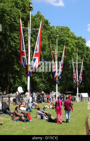 Les gens se détendre sur l'herbe à côté de Victoria Memorial parade après la Couleur , , Londres , Angleterre Banque D'Images