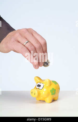 Hambourg, Allemagne, un Maennerhand mettre un euro dans la tirelire Banque D'Images