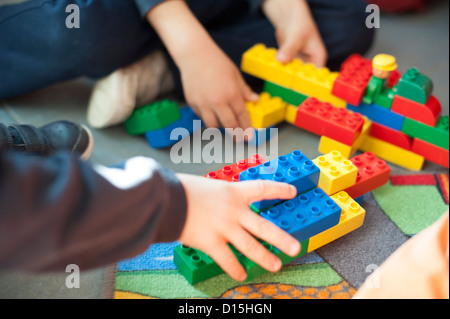 Mains d'un enfant jouant avec des blocs de construction Banque D'Images