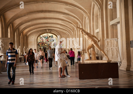 Les touristes regardent vers la statuaire grecque antique - Musée du Louvre, Paris Banque D'Images