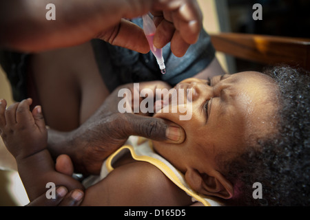 Un enfant reçoit un vaccin oral dans un centre de santé sur l'île de Bussi, Ouganda, Afrique de l'Est. Banque D'Images