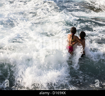Jeune couple dans le surf sur le Malecon à La Havane Cuba Banque D'Images
