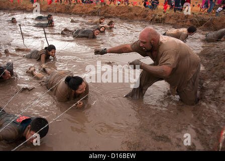 8 décembre 2012 San Antonio, Texas, USA - Les personnes à vaincre l'obstacle de boue pendant le Gladiateur Rock'n courir à San Antonio. Banque D'Images