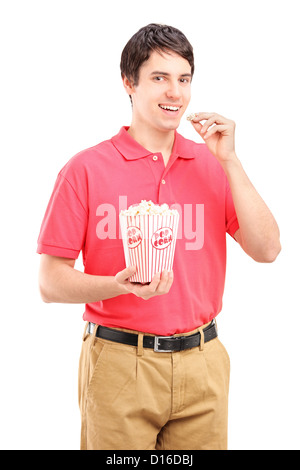 Young smiling man eating popcorn isolé sur fond blanc Banque D'Images