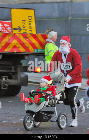 Dimanche 9 décembre 2012, Glasgow City Centre, Écosse, Royaume-Uni, Glasgow 5k Santa Dash.UN père et un enfant en robe de fantaisie prennent part à la course annuelle de charité de Santa. Banque D'Images