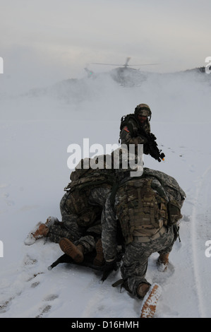 Les soldats de l'Armée américaine à partir de la 541e compagnie du génie de protéger une victime simulée de le souffle du rotor d'un UH-72 Lakota au cours d'un exercice d'entraînement situationnel (STX) au Centre de préparation interarmées multinationale à Hohenfels, Allemagne, le 3 décembre 2012. La STX est Banque D'Images