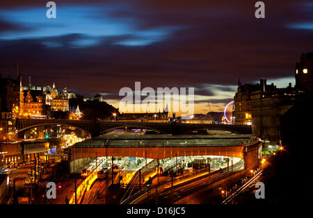 Coucher de soleil sur la gare de Waverley d'Édimbourg et le centre-ville de fête, montrant l'arbre de Noël sur la butte et à droite la grande roue de la foire de pics de derrière l'Hôtel Balmoral, Écosse, Royaume-Uni, 09 décembre 2012. Banque D'Images