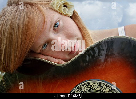 Une belle jeune fille est capturé tenant sa guitare acoustique. Banque D'Images