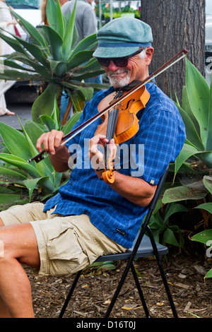 Un homme âgé avec un chapeau joue du violon alors qu'assis sur le marché des fermiers dans "Santa Barbara", en Californie Banque D'Images