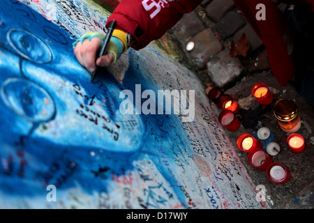 Enfant écrivant un message sur le portrait de John Lennon Wall Prague Street art République Tchèque graffiti Banque D'Images