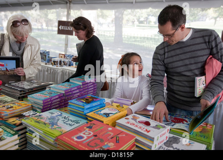 Jeune fille montre son père un livre au Children's tente où livre sont vendus au cours de la fête du livre à Austin au Texas Banque D'Images