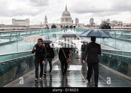 Cathédrale St Paul London Millennium Bridge avec les banlieusards avec parasols Banque D'Images