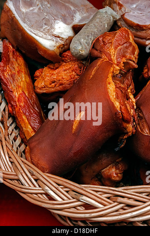 Jambon de porc et saucisses placées dans un panier en osier. Banque D'Images