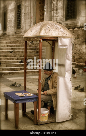 Alimentation Pigeon vendeur dans la vente de graines stand près du détroit du Bosphore à Istanbul Turquie Banque D'Images