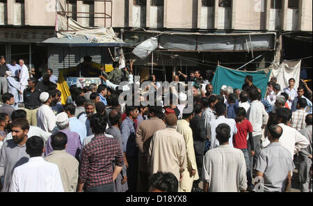 Les gens se rassemblent près de grenade à main boutique après l'attaque par l'extorsion mafia, lors d'une manifestation de protestation au Tibet Centre à Karachi le Mardi, Décembre 11, 2012. Activités à Karachi d'extorsion mafia sont sur le pic de production, ils font harceler la classe affaires en faisant un tel genre d'activités destructrices et de la demande de l'argent. Banque D'Images