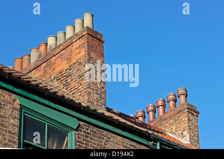 Vieux pots de cheminée sur un toit Selby contre un ciel bleu clair Banque D'Images
