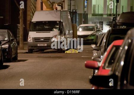 Londres, Royaume-Uni. 11/12/12. Agent de police métropolitaine entouré par des éclats de verre étudie sous le véhicule suspect. Le van est garé sur Abbey Orchard Street, non loin du Club conservateur et de New Scotland Yard. Fermeture de routes étaient en place à Victoria Street, Rochester Row, Marsham Street autour de l'Office des étrangers. Banque D'Images