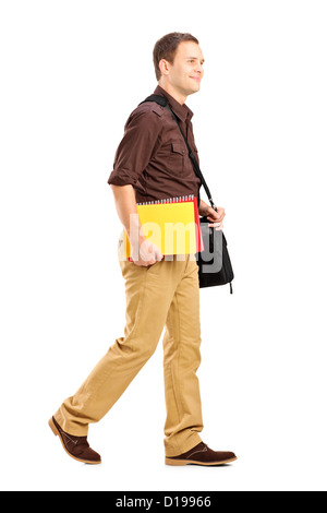 Portrait d'un étudiant avec sac d'épaule holding books et la marche à pied isolé sur fond blanc Banque D'Images