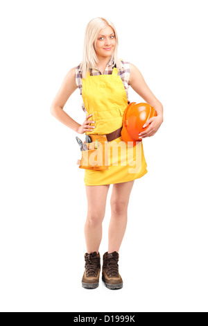 Portrait d'un travailleur féminin souriant avec une ceinture à outils holding helmet isolé sur fond blanc Banque D'Images