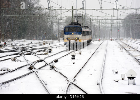 Un train arrive sur un couvert de neige en hiver la gare Banque D'Images