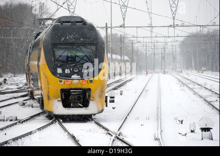 Un train arrive sur un couvert de neige en hiver la gare Banque D'Images