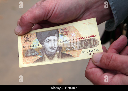 Un homme montre un billet de 100 lev de Bulgarie. Banque D'Images