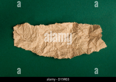 Brown papier déchiré sur fond vert sombre Banque D'Images