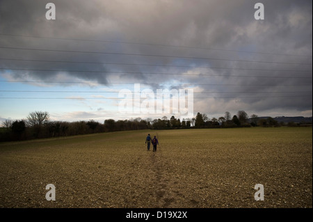 Les promeneurs traversant un champ sur le sentier national Ridgeway près de Chinnor, España Banque D'Images